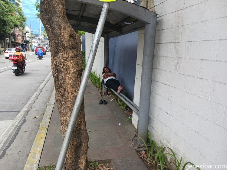 バス停で寝るホームレス